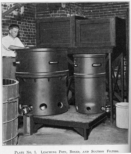 In Pickard Hall, a researcher maneuvers a drum used in the extraction of radium from carnotite ore
